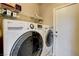 Convenient laundry room with modern washer and dryer units, plus shelving and a door to the outside at 5827 Delonee Skies Ave, Las Vegas, NV 89131