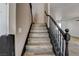 View of the wooden staircase with black balusters and railing, ascending to the upper level of the home at 5827 Delonee Skies Ave, Las Vegas, NV 89131