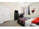 Comfortable bedroom with neutral walls, grey wood floors, and a black dresser at 5832 Ivy Vine Ct, Las Vegas, NV 89141