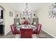 Dining area featuring a glass table, chandelier, and decorative gray chairs at 5832 Ivy Vine Ct, Las Vegas, NV 89141