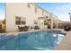 A beautiful backyard featuring a private pool with blue tile accents, set against the home's architecture with a balcony overhead at 5832 Ivy Vine Ct, Las Vegas, NV 89141