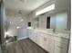 Modern bathroom featuring dual sinks, white cabinetry, quartz countertops, and a tiled shower at 6360 Montclair St, Pahrump, NV 89061