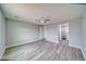 Spacious bedroom with ceiling fan and wood-look floors leads to en-suite bathroom at 6360 Montclair St, Pahrump, NV 89061