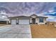 New construction home featuring a three car garage and desert landscaping at 6360 Montclair St, Pahrump, NV 89061