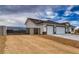 Side view of a new construction home featuring a three car garage and gravel landscaping at 6360 Montclair St, Pahrump, NV 89061