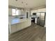 Bright kitchen featuring white cabinetry, stainless steel appliances, and a large island with a quartz countertop at 6360 Montclair St, Pahrump, NV 89061