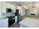 Modern kitchen featuring white cabinets, stainless steel appliances, and a large island overlooking the living room at 6360 Montclair St, Pahrump, NV 89061