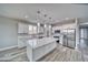 Modern kitchen featuring white cabinets, stainless steel appliances, and a large center island with quartz countertop at 6360 Montclair St, Pahrump, NV 89061