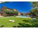 Spacious backyard with an in-ground pool, green lawn, and an outdoor lounge area perfect for entertaining at 6391 Tempting Choice Ave, Las Vegas, NV 89131