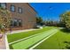 Large backyard featuring a bocce ball court, grass, trees, and patio lighting at 6391 Tempting Choice Ave, Las Vegas, NV 89131