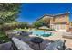 Backyard paradise features a sparkling pool, spa, and outdoor seating for relaxing and entertaining at 6391 Tempting Choice Ave, Las Vegas, NV 89131
