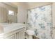 Bright bathroom features white vanity and floral shower curtain at 6391 Tempting Choice Ave, Las Vegas, NV 89131