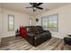 Bright bedroom features a ceiling fan, shutters, and a comfortable leather couch, offering a relaxing retreat at 6391 Tempting Choice Ave, Las Vegas, NV 89131