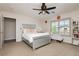 Cozy bedroom features carpet, an accent chair, stylish bed frame, and relaxing ceiling fan at 6391 Tempting Choice Ave, Las Vegas, NV 89131