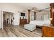 Primary bedroom featuring luxury four poster bed, wood floors, and window shutters at 6391 Tempting Choice Ave, Las Vegas, NV 89131