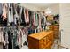 Organized walk-in closet with hanging racks, shelves, and wooden drawers at 6391 Tempting Choice Ave, Las Vegas, NV 89131