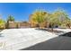 Spacious driveway leading to a two-story home with mature trees at 6391 Tempting Choice Ave, Las Vegas, NV 89131