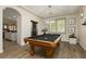 Well-lit game room with a classic wooden pool table, stylish lighting, and neutral walls, perfect for entertaining at 6391 Tempting Choice Ave, Las Vegas, NV 89131