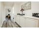 Clean hallway with light wood floors and decorations on a built-in shelf at 6391 Tempting Choice Ave, Las Vegas, NV 89131