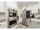 Modern kitchen featuring stainless steel appliances, light gray backsplash, and white cabinets at 6391 Tempting Choice Ave, Las Vegas, NV 89131