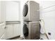 Laundry room features stacked washer and dryer units with adjacent granite countertop at 6391 Tempting Choice Ave, Las Vegas, NV 89131