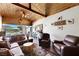 Cozy living room with wood ceiling beams, leather furniture, and a view of the backyard at 6391 Tempting Choice Ave, Las Vegas, NV 89131