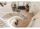 Staircase with a view of an open-concept living room with leather seating and lots of natural light at 6391 Tempting Choice Ave, Las Vegas, NV 89131