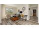 Comfortable living room boasts a work area, cozy sofa, wood floors and an abundance of natural light at 6391 Tempting Choice Ave, Las Vegas, NV 89131