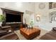 Inviting living room with soaring ceilings features a leather ottoman and staircase to the upper level at 6391 Tempting Choice Ave, Las Vegas, NV 89131