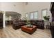 Spacious living room featuring a comfortable brown leather sectional, light wood floors, and ample natural light at 6391 Tempting Choice Ave, Las Vegas, NV 89131