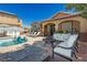 Outdoor living area with comfortable seating around a fire pit, next to a sparkling pool at 6391 Tempting Choice Ave, Las Vegas, NV 89131