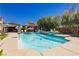 Beautiful backyard pool with lounge chairs, patio umbrellas, and lush landscaping, ideal for summer relaxation at 6391 Tempting Choice Ave, Las Vegas, NV 89131