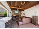 Pool house interior featuring a bar, seating, wood accents, and a stone fireplace at 6391 Tempting Choice Ave, Las Vegas, NV 89131
