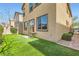 A vibrant backyard with artificial turf, a table set, and verdant landscaping at 6629 Breakwater Reef St, Las Vegas, NV 89149