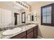 Bathroom features dual sinks, granite countertop, and window with plantation shutters at 6629 Breakwater Reef St, Las Vegas, NV 89149