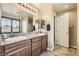 Double sink bathroom featuring granite countertops, wood cabinets, a large mirror, and a private water closet at 6629 Breakwater Reef St, Las Vegas, NV 89149