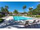 Community pool surrounded by lounge chairs and palm trees on sunny day at 6959 Emerald Springs Ln, Las Vegas, NV 89113