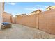 The gravel backyard features a block wall dividing properties and an air conditioning unit at 6989 Walden Park St, Las Vegas, NV 89166