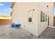 A view of the side and back of this home, showing the textured siding, windows and the gravel yard at 6989 Walden Park St, Las Vegas, NV 89166