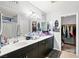 Bathroom features dual sinks, framed mirrors, a shower/tub combination and entry to walk-in closet at 6989 Walden Park St, Las Vegas, NV 89166