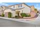 A two-story house features a two-car garage, landscaped front yard, and neutral stucco facade at 6989 Walden Park St, Las Vegas, NV 89166