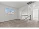 Bright living room with neutral carpet, large window, and staircase access at 7020 English Mist Cir, Las Vegas, NV 89128