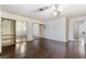 The primary bedroom features a ceiling fan, mirrored closet doors, and dark wood-look floors at 706 Morrocco Dr, Henderson, NV 89002