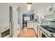 Bright galley kitchen featuring white appliances and white cabinetry with an eat-in area at 7632 Amato Ave, Las Vegas, NV 89128