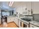 Cozy kitchen featuring white cabinets, granite countertops, and appliances with backyard view at 7632 Amato Ave, Las Vegas, NV 89128