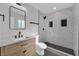 Bathroom featuring a wood vanity, shower with a tiled backsplash and sleek glass door and black hardware at 905 Antelope Way, Las Vegas, NV 89145