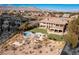 Aerial view of a luxurious home featuring a unique pool design, expansive lawn, and neighborhood in the background at 9631 Orient Express Ct, Las Vegas, NV 89145