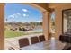 A covered patio includes an outdoor dining table with a view of pool and manicured yard at 9631 Orient Express Ct, Las Vegas, NV 89145