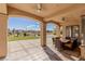 Covered patio with a dining table and chairs, with views of the manicured lawn and pool area at 9631 Orient Express Ct, Las Vegas, NV 89145