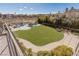 Well-manicured backyard features a pristine pool with lounge seating and lush trees on a sunny day at 9631 Orient Express Ct, Las Vegas, NV 89145